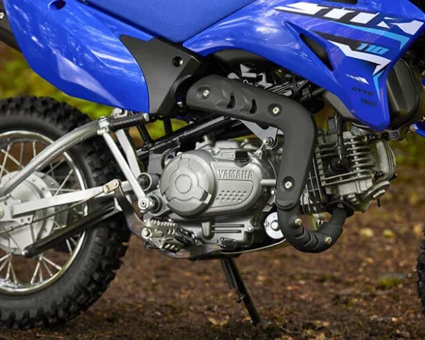Close-up of the Yamaha TT-R110E engine and blue side panels